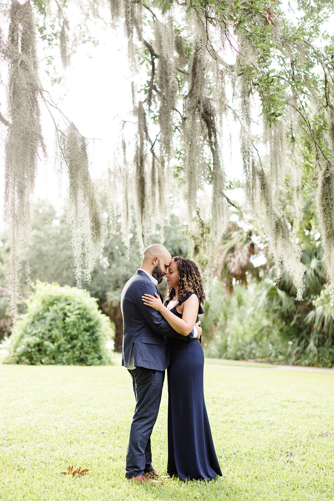 Engagement photo of couple in New Orleans, Louisiana at City Park under moss covered trees