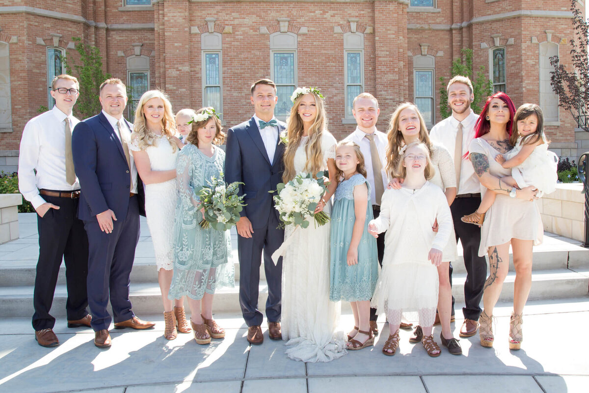 a wedding couple with family at their sunny utah wedding