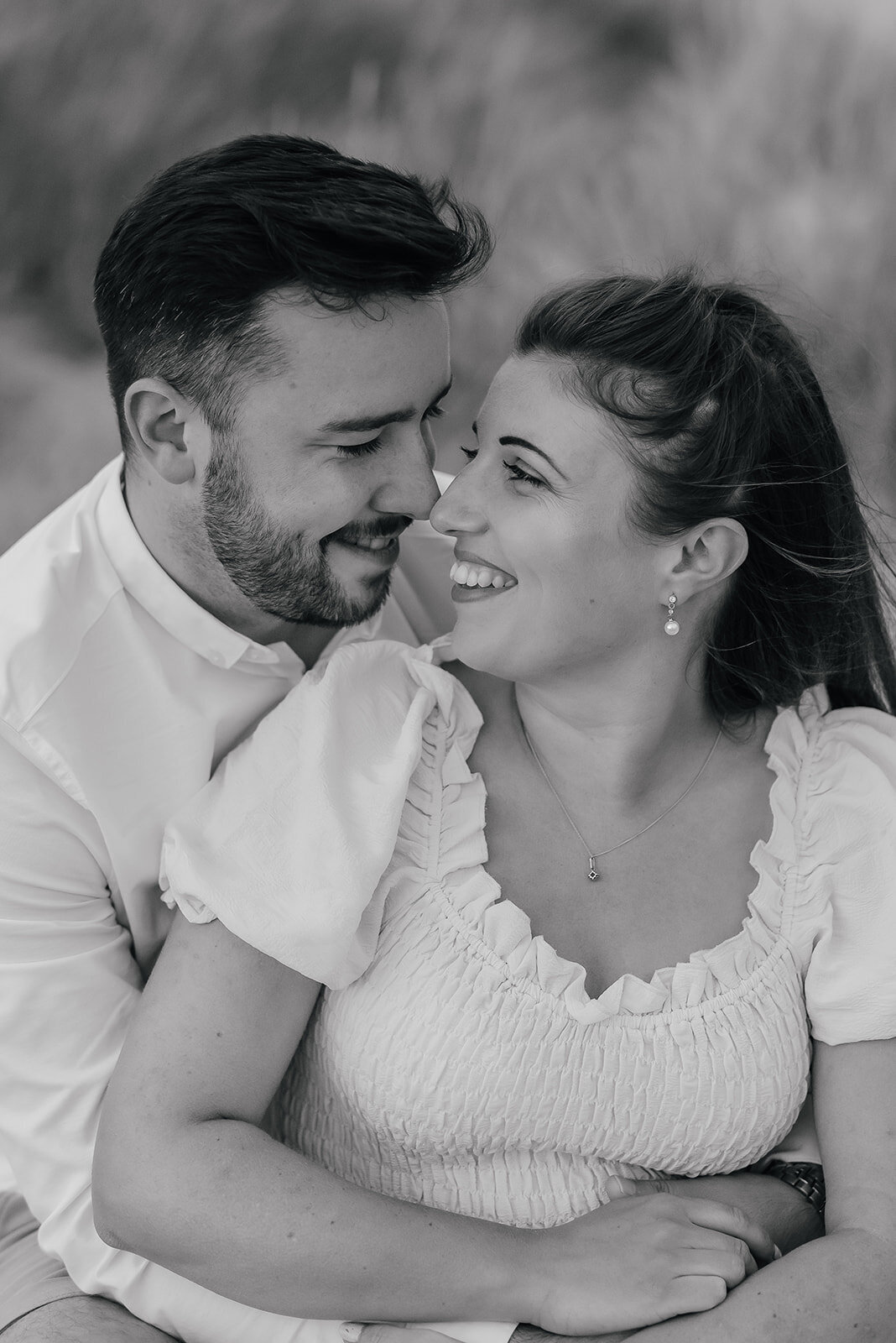 Couple sit closely together looking into each others eyes