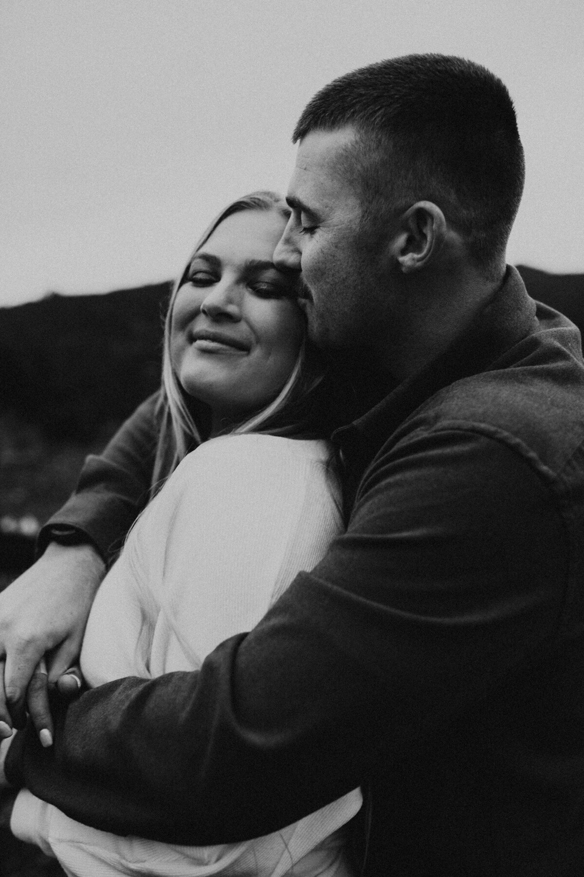 Groom holds his bride and smiles in engagement shoot in Monmouth Oregon