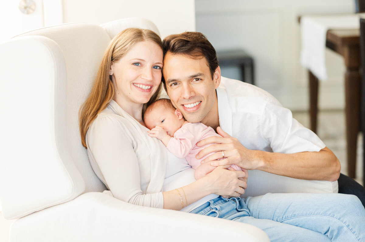 Newborn with mom and dad in chair taken in Westwood, MA by best Westwood newborn photographer