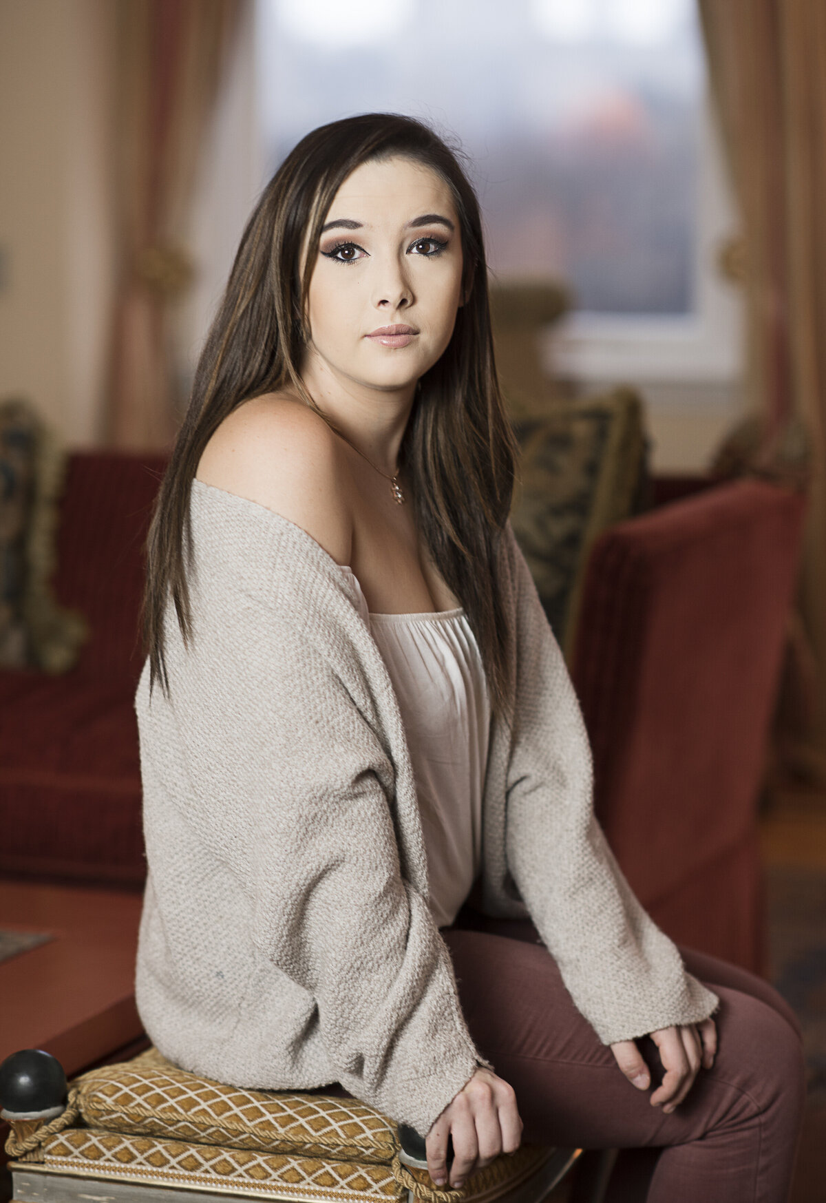 A person sitting on a small bench and looking to the side