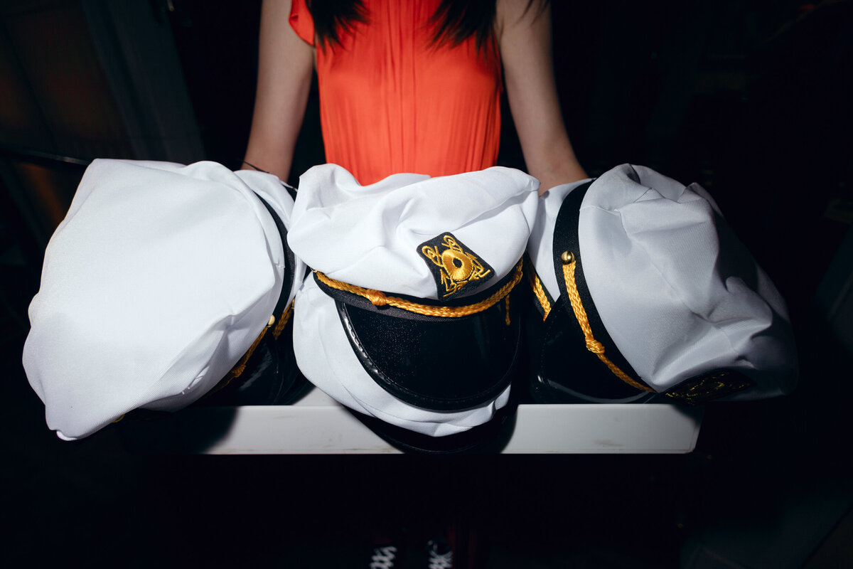 A wedding photo of sailors hats given out to guests during the wedding reception