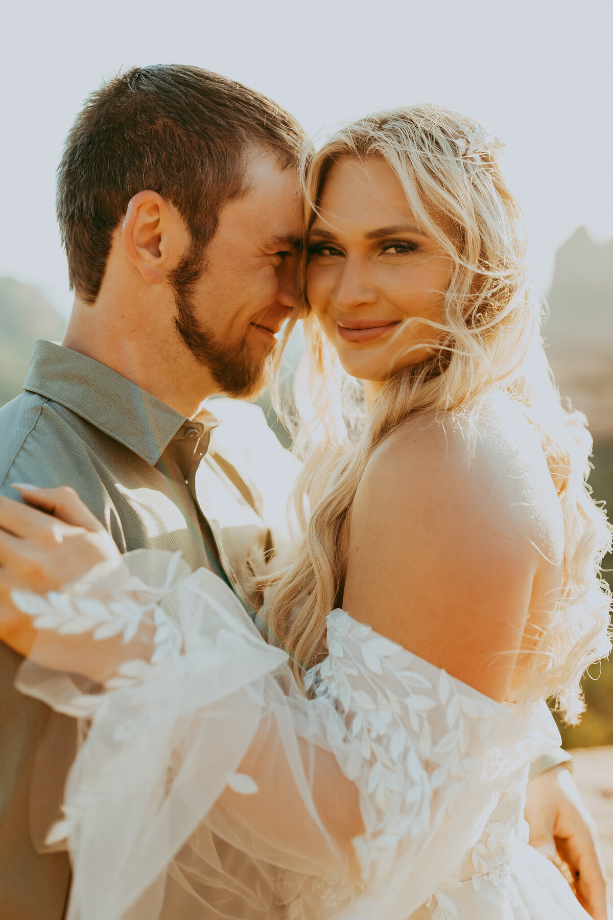 bride smiles at camera with groom next to her