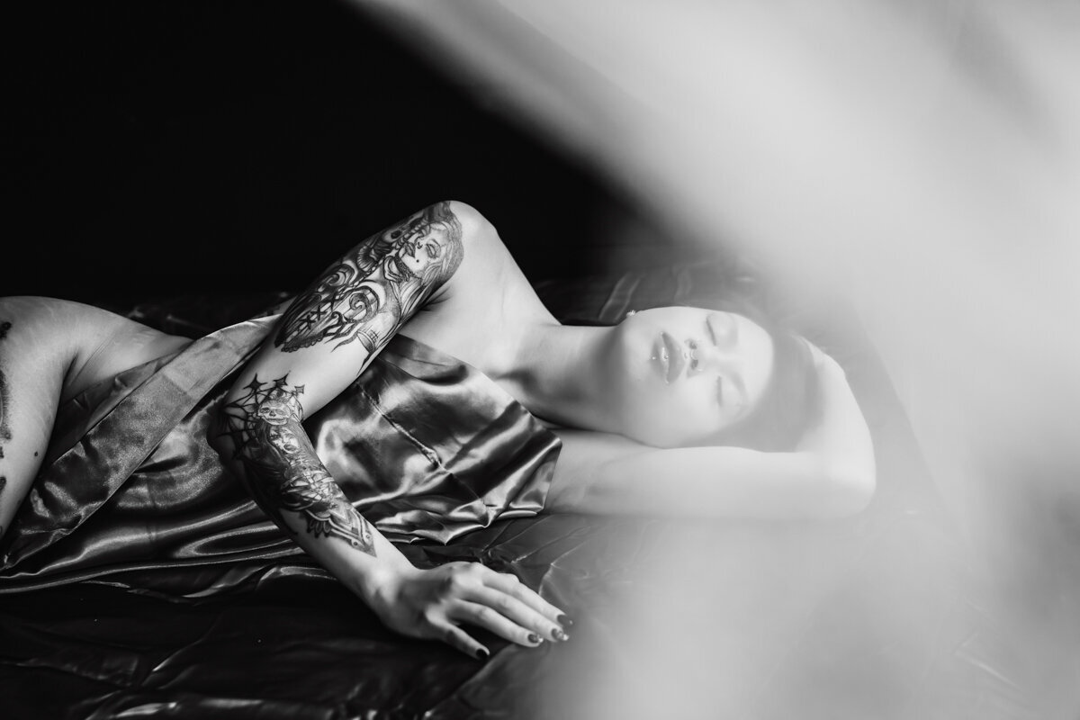 Black and whit image of woman laying peacefull on a bed in Minneapolis MN