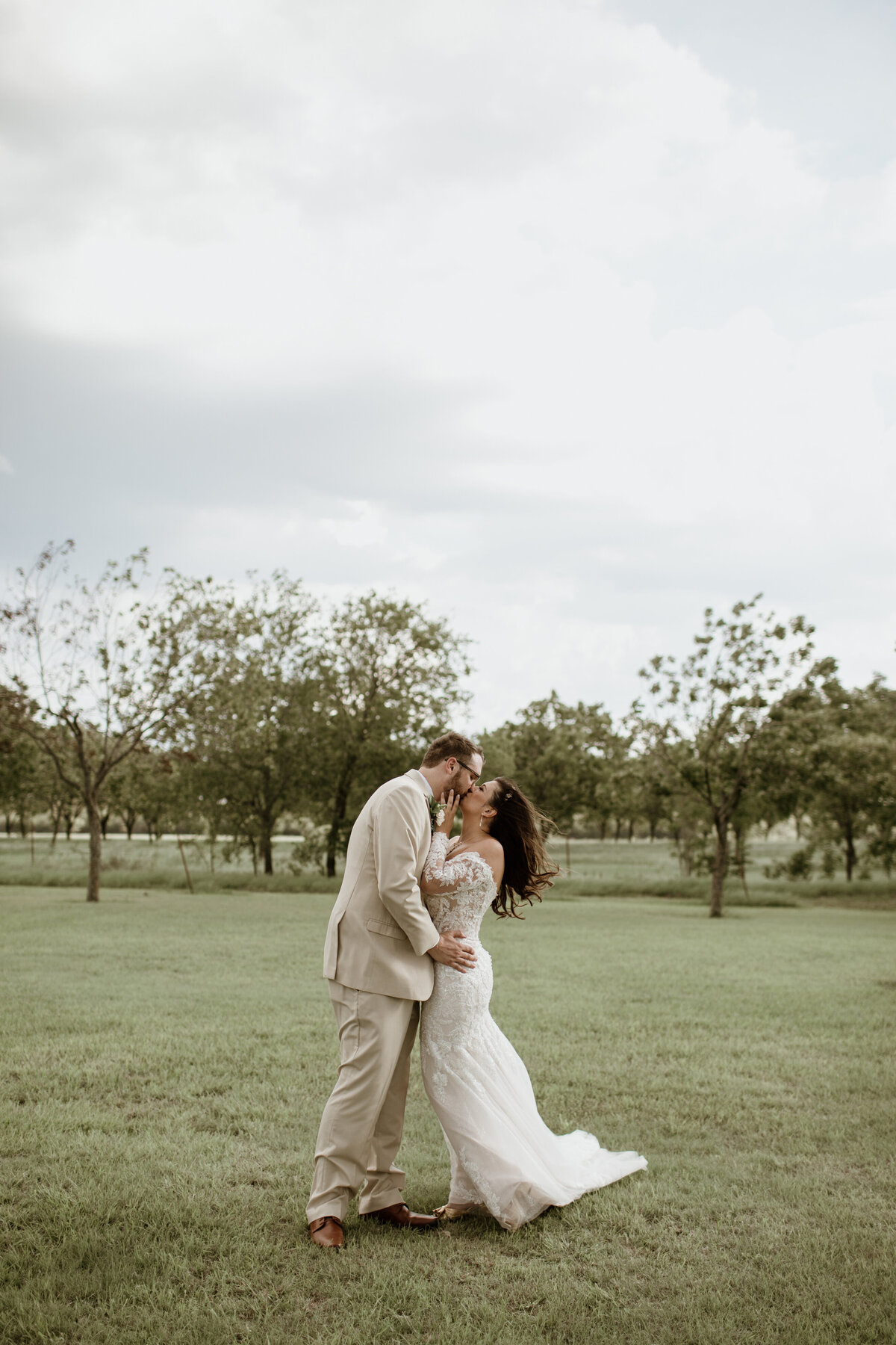 A romantic kiss shared between a bride and groom at Pecan Creek Farm in Venus Texas. Captured by Fort Worth Wedding Photographer, Megan Christine Studio