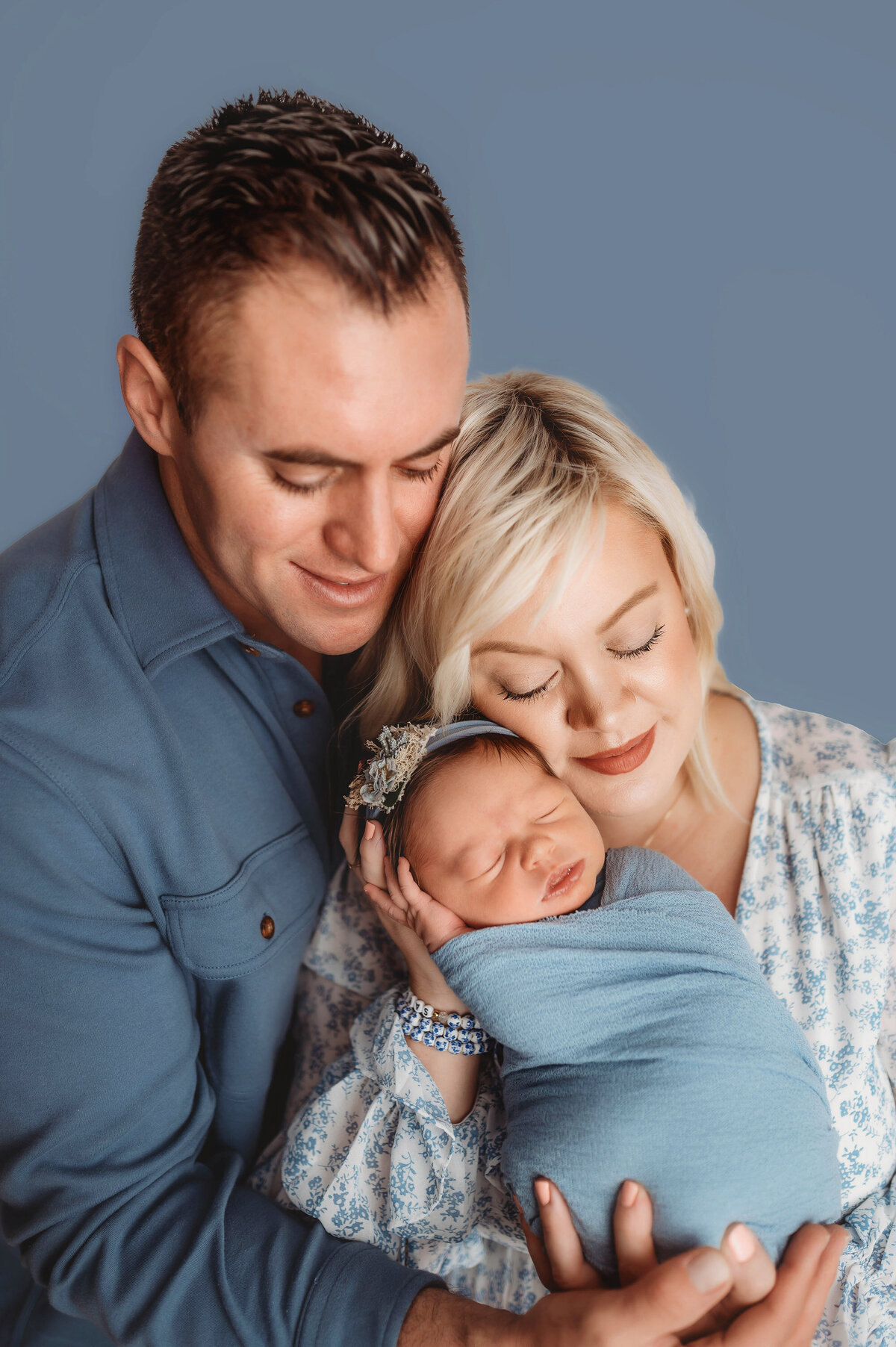 Parents embrace their newborn during Newborn Photoshoot in Charleston.