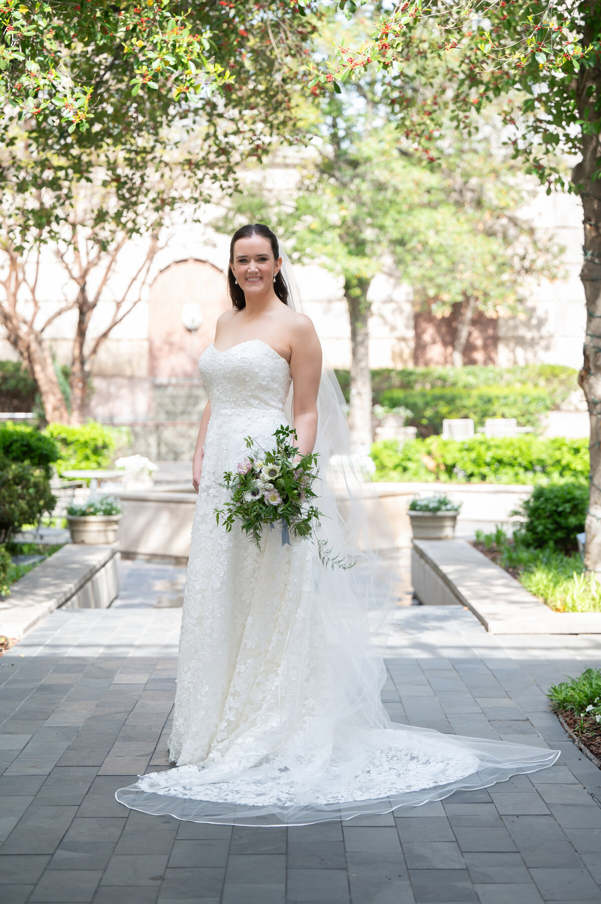 Bride in a strapless lace gown with cathedral veil, for bridal portraits in Dallas