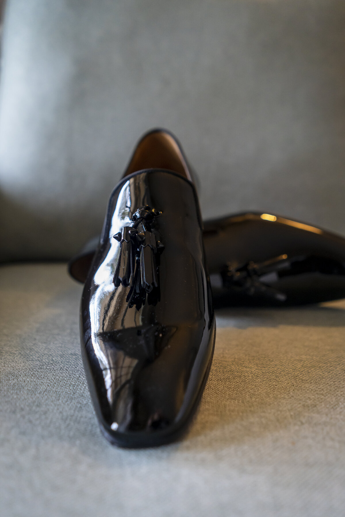 Black loafers sitting on a couch.