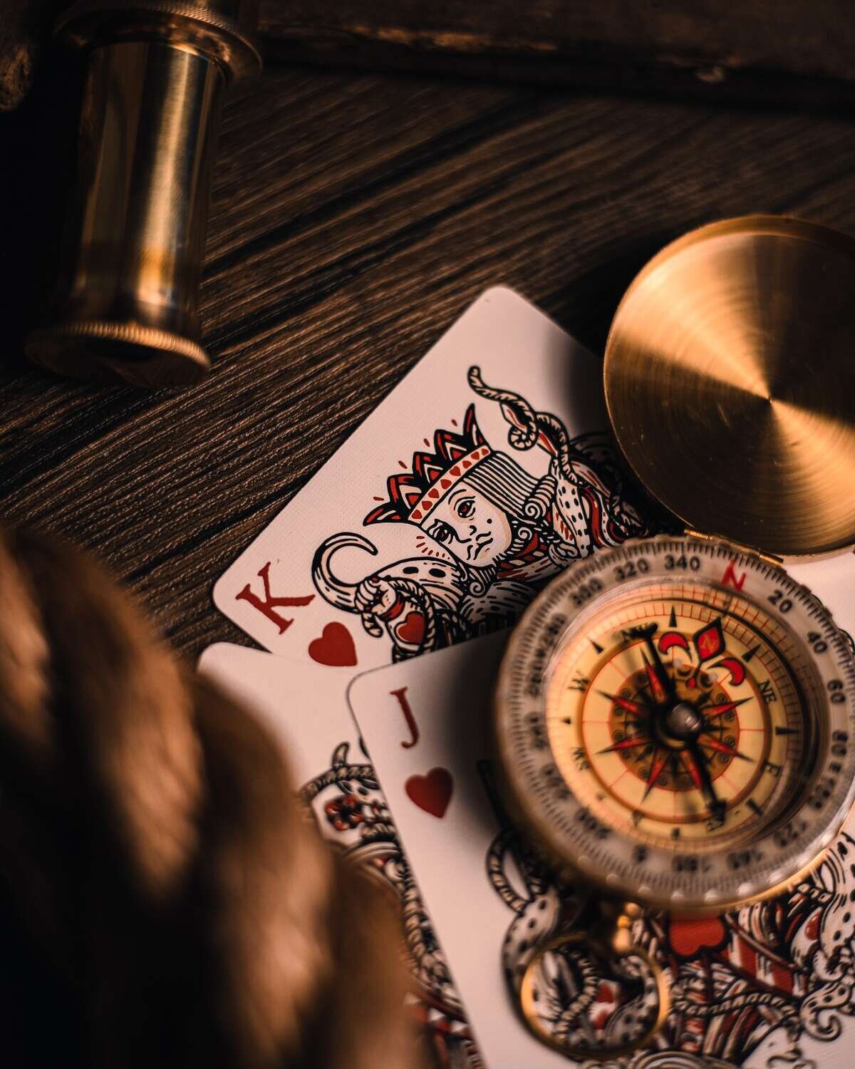 Joker and king playing cards with compass on top