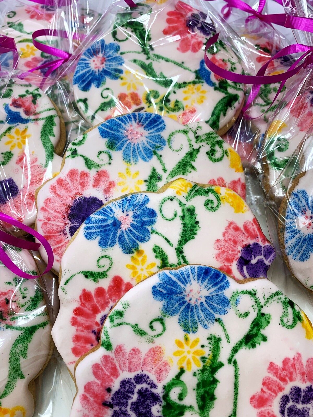 Colorful painted flower cookies in red, pink, yellow, blue, purple, and green