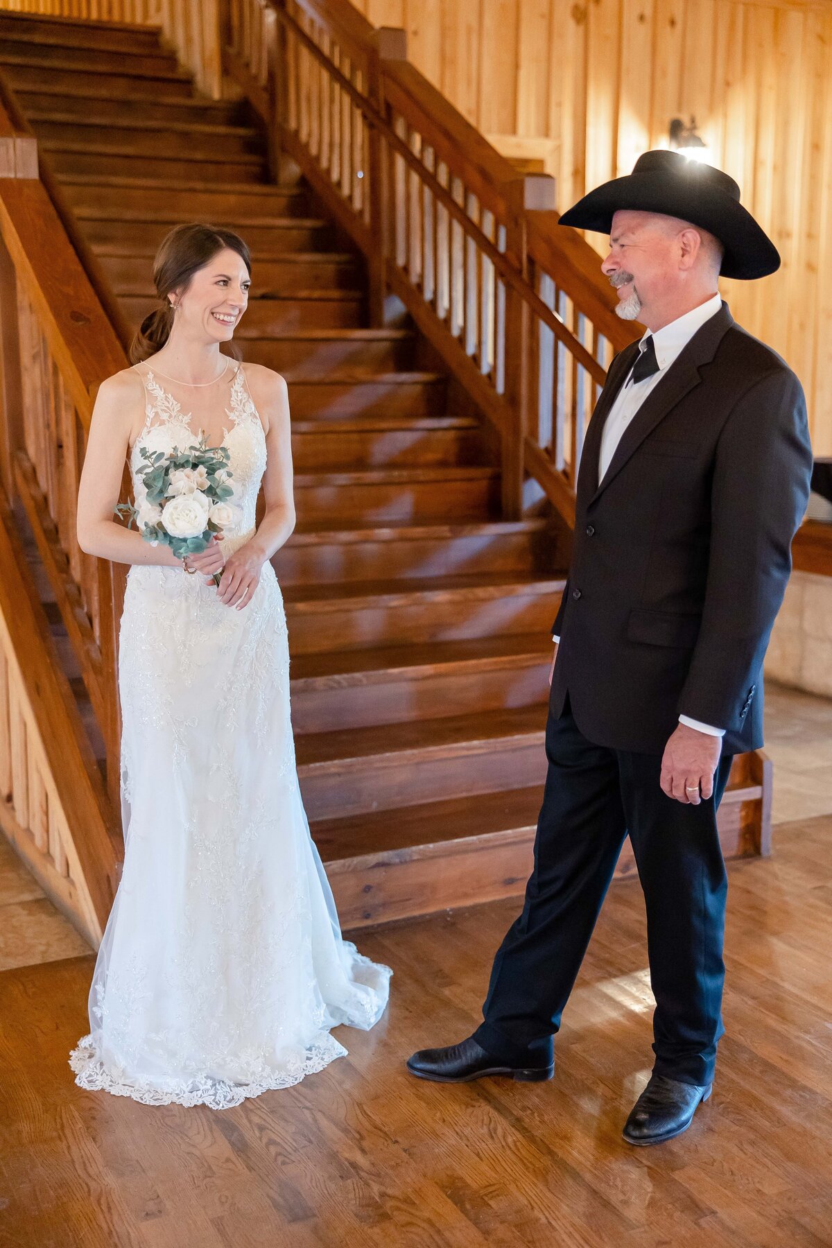 bride and father smile at each other at base of steps at Milestone Boerne Texas wedding