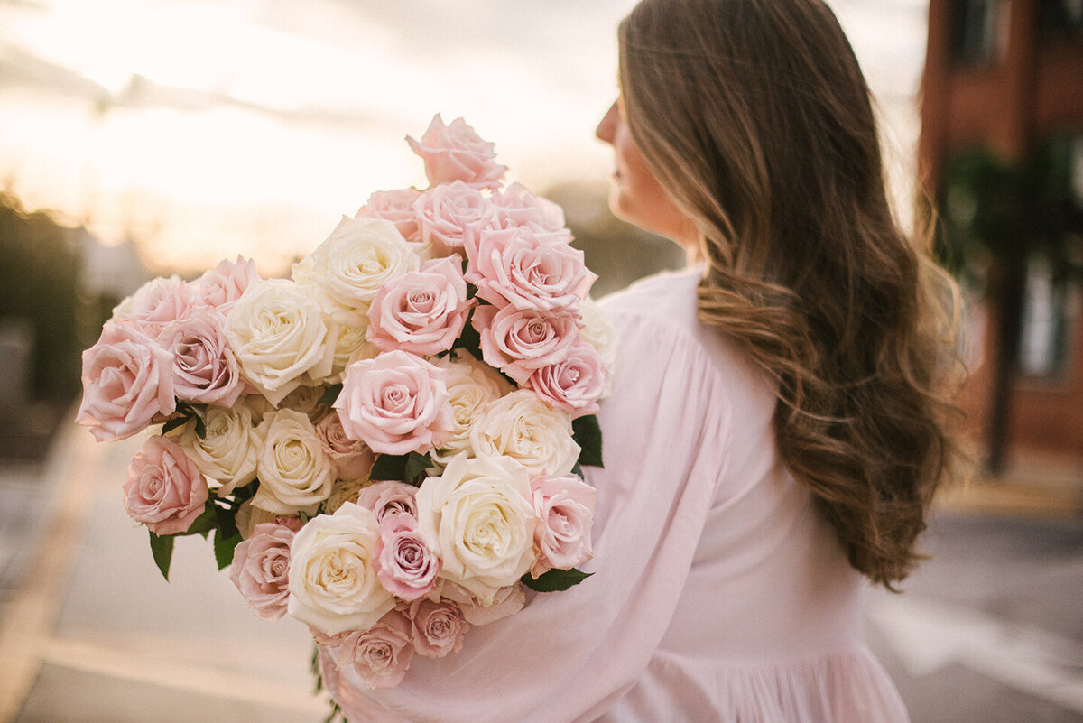 Abby McDonald, owner of Abby Grace Florals, holding a big bouquet of roses in Anderson, SC