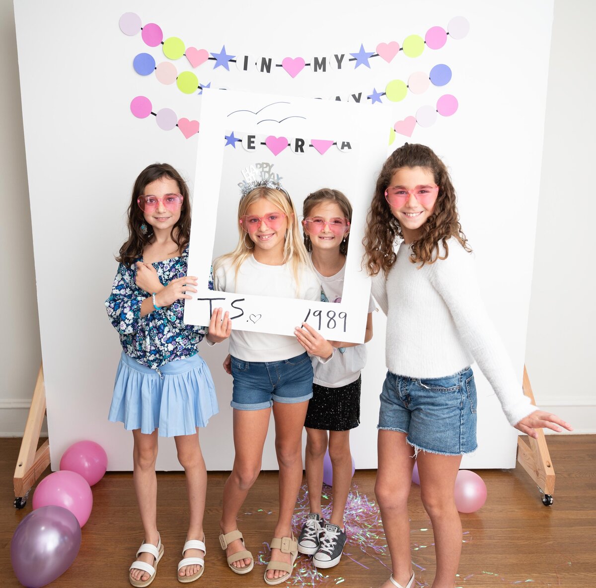 4 girls with polaroid cut out at taylor swift themed birthday party