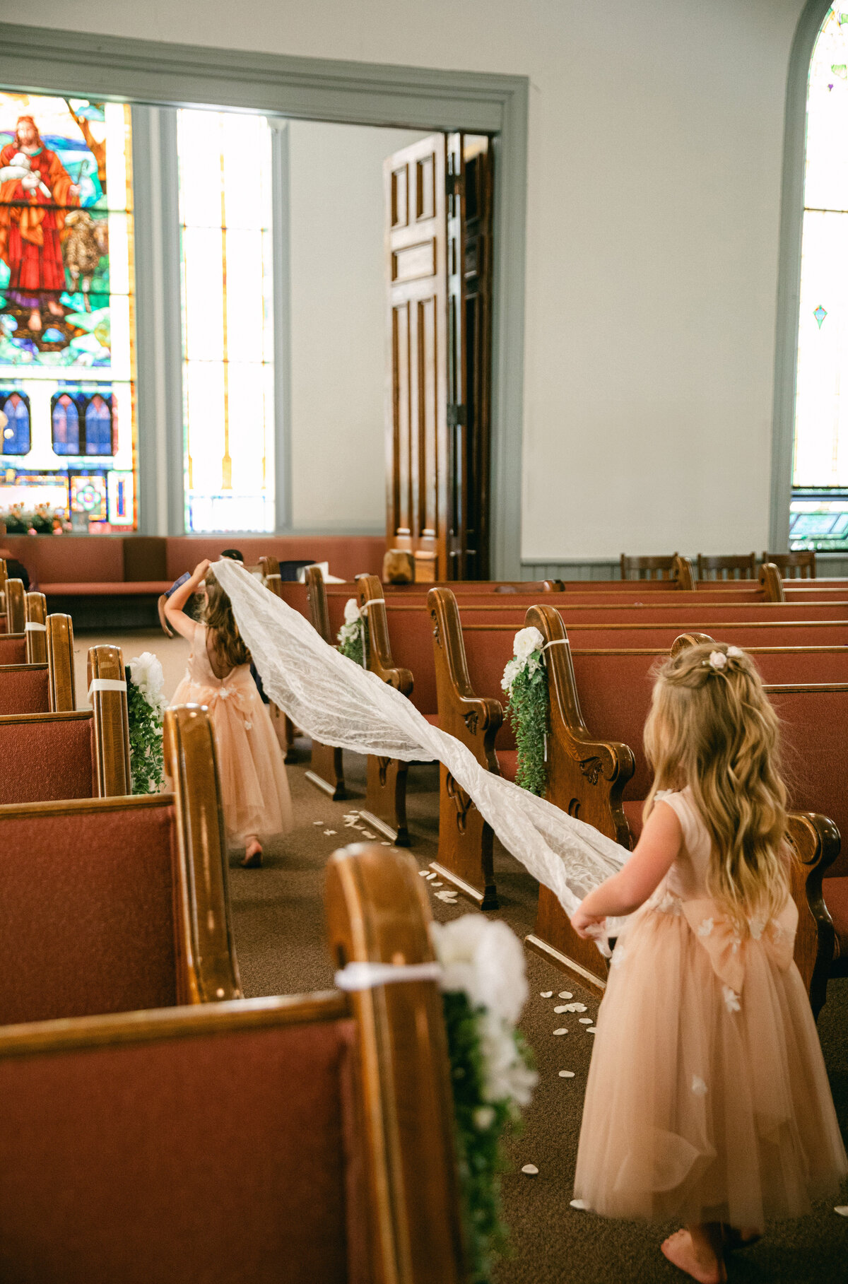 flower-girls-carrying-veil-down-aisle