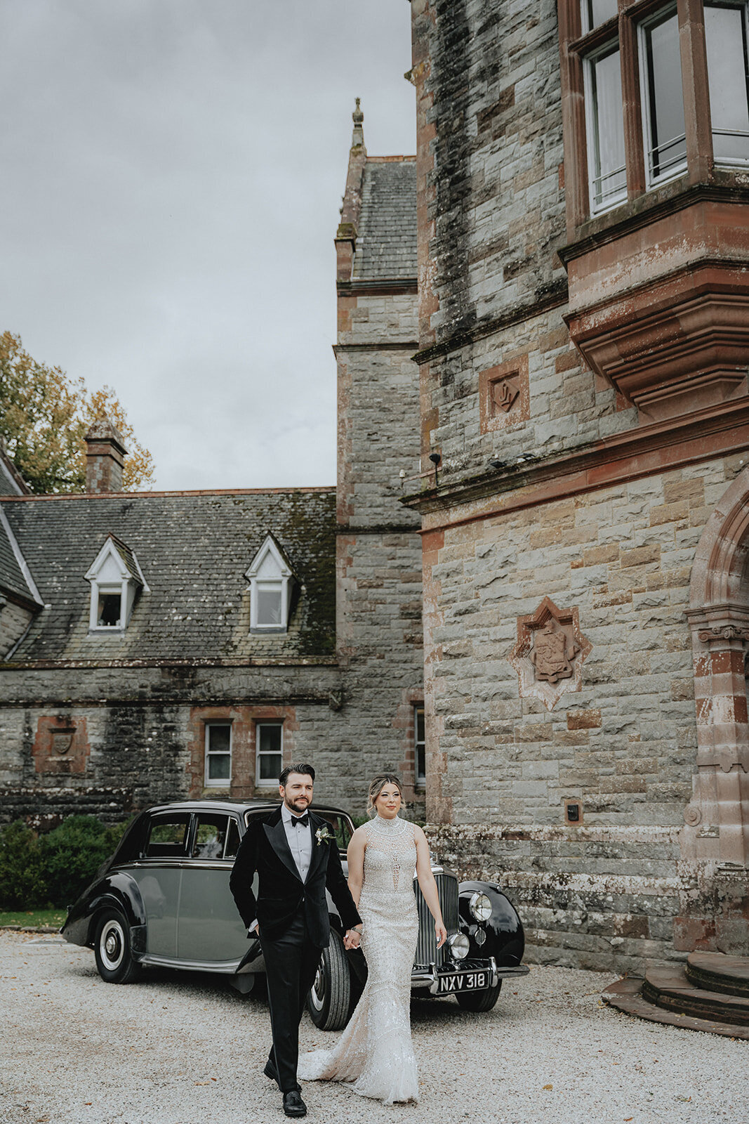 Bride and groom walking with castle in background in Ireland