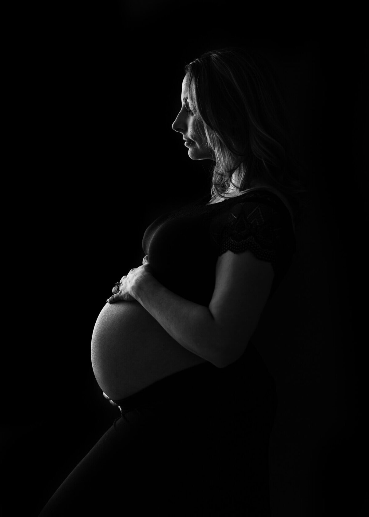 rim lighting on pregnant belly in black and white