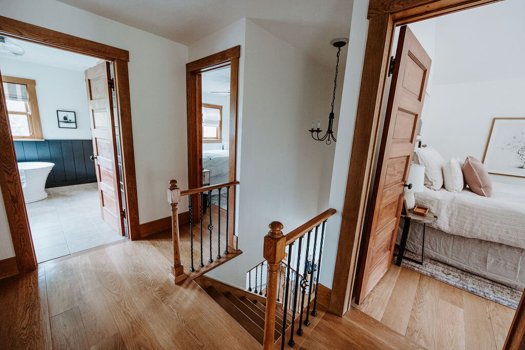 the second floor of the modern farmhouse overnight accommodations at Willowbrook wedding venue with a view of a neutral bedroom and a free standing soaking tub