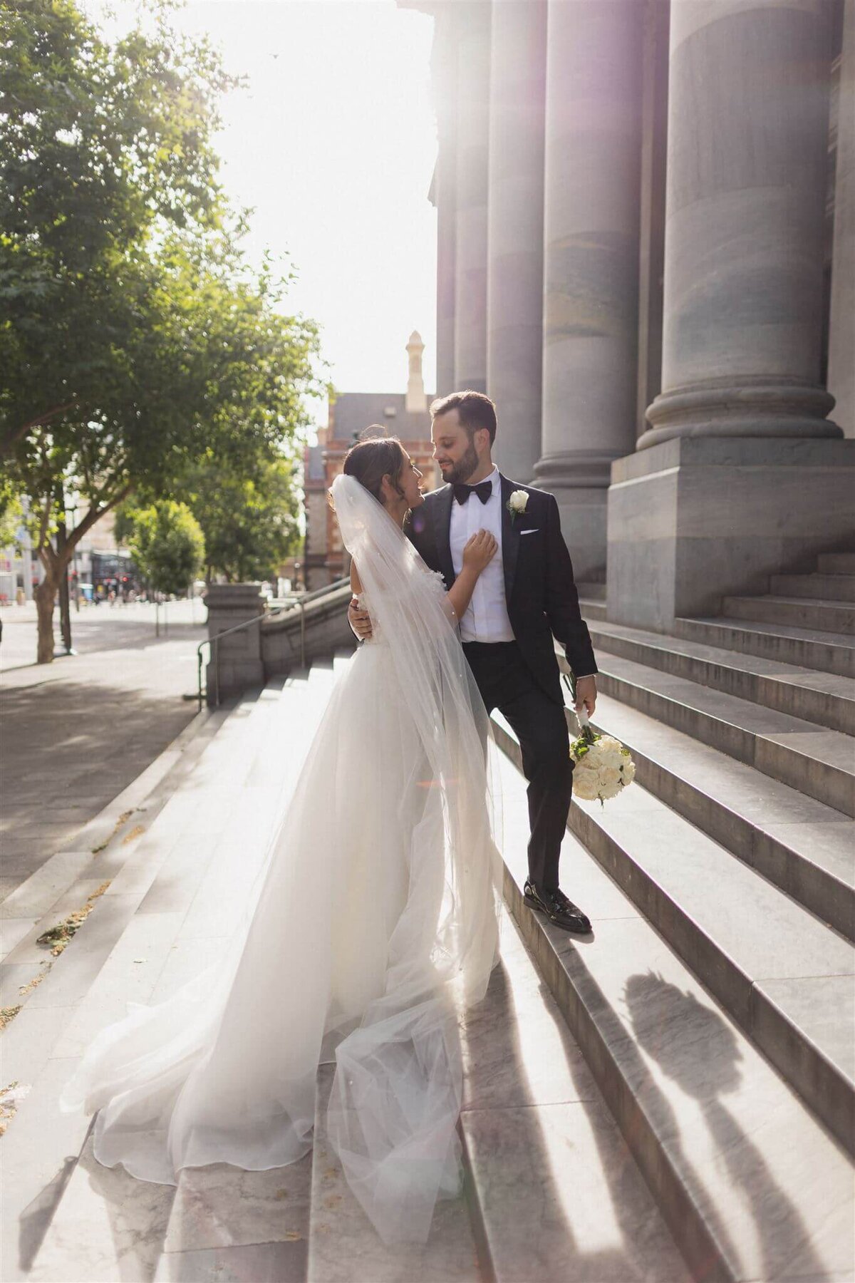 Candid wedding photo of a couple laughing together outdoors.

