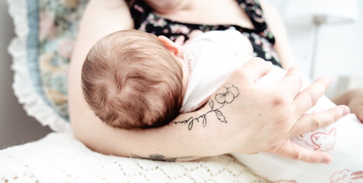 A new mom holds her two day old baby in her lap in her Edmonton home