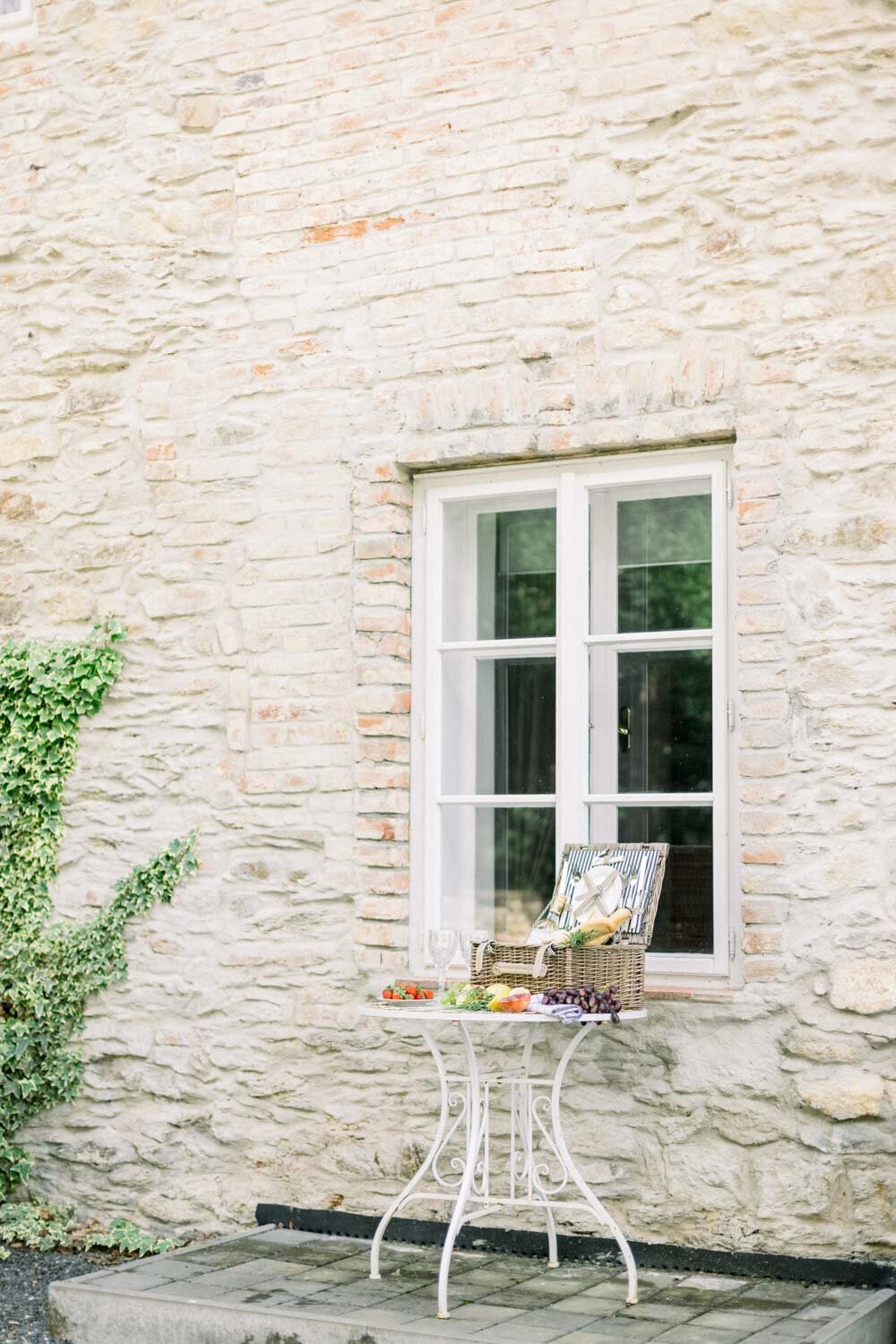 okno a stoleček a piknikový koš u vily v toskánském stylu
