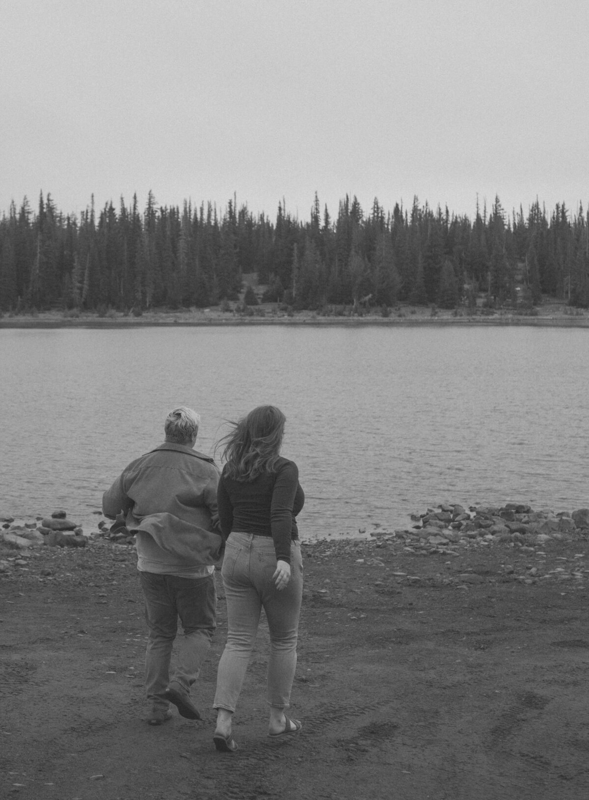 couple running and being playful near the lake in Bend, Oregon