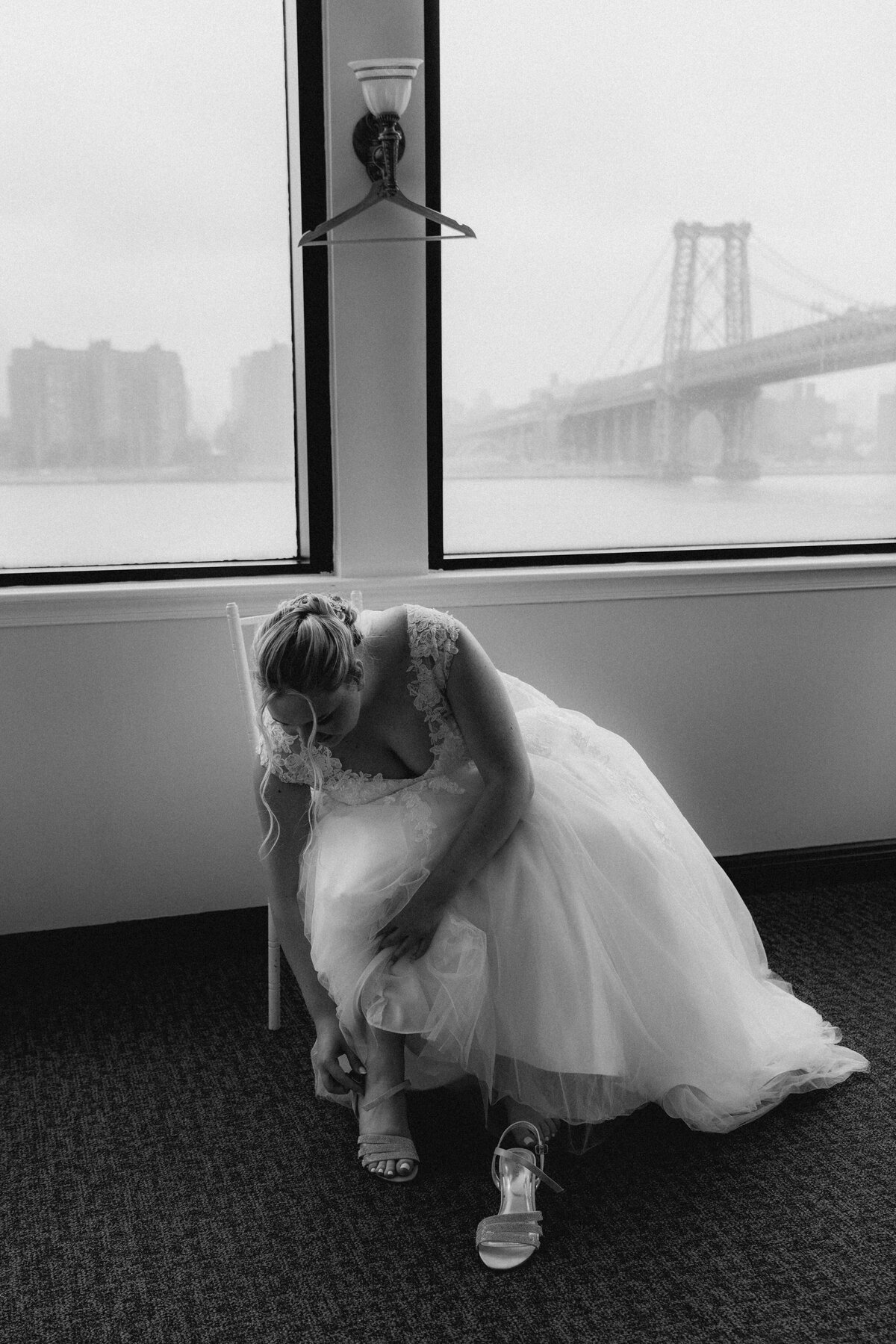 a bride looks down as she puts on her shoe