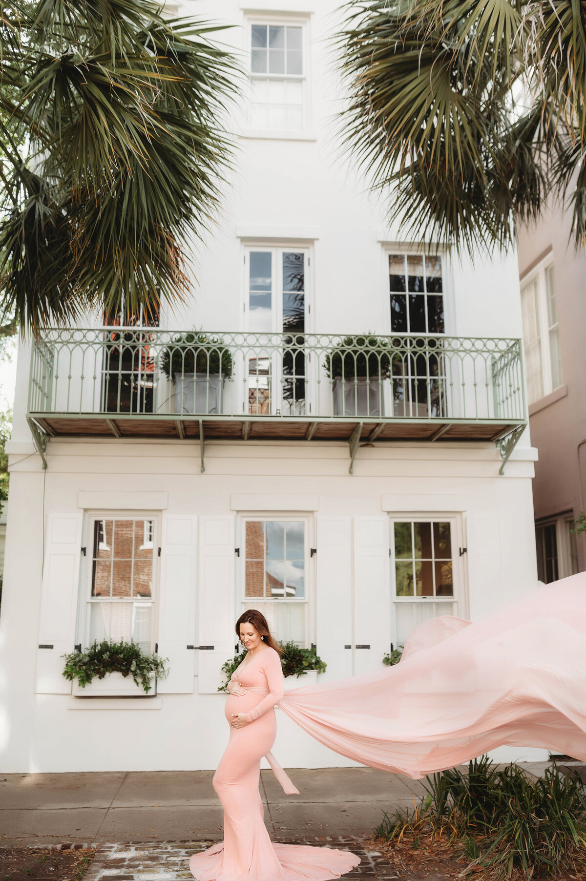 Pregnant woman poses for Maternity Photos at Rainbow Row in Charleston, SC.
