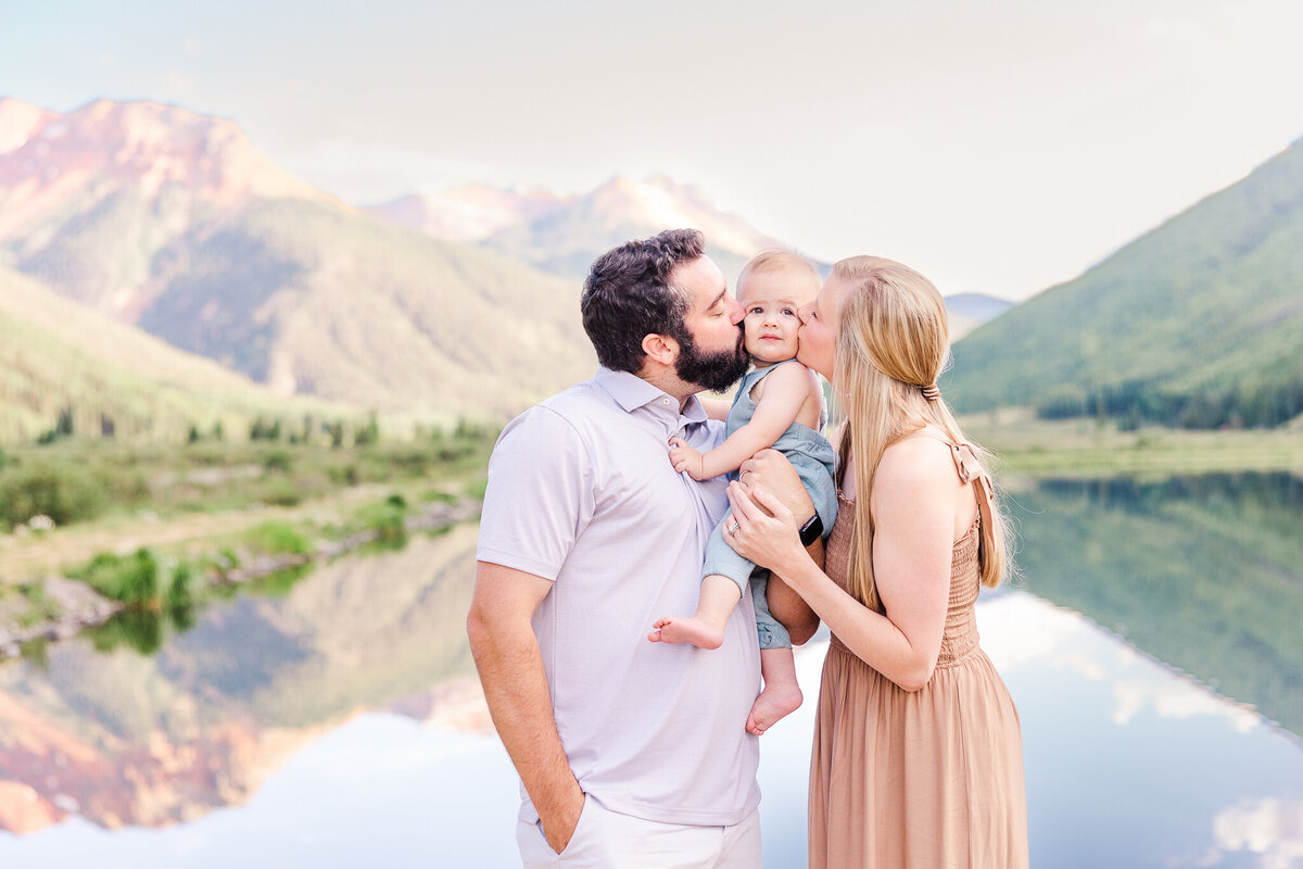 mom and dad kissing little boy at crystal lake on red mountain pass ouray co
