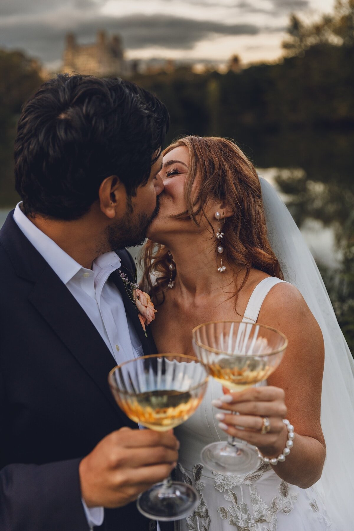 Bride and groom toasting with gold-rimmed glasses