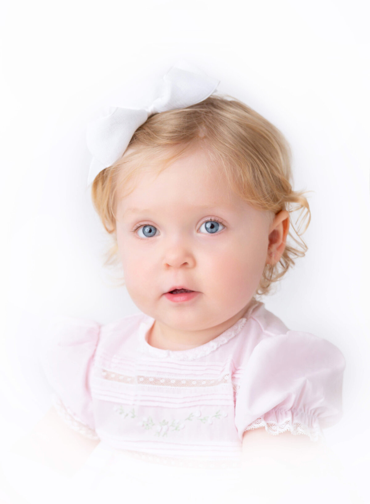 Close-up modern Heirloom portrait of a baby girl with blue eyes and soft curls — fine-art baby photography in NYC by Brooklyn Heirloom photographer.