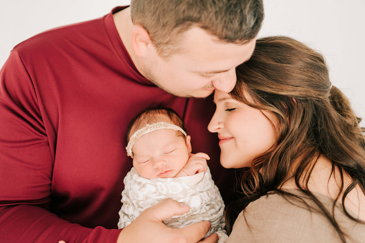 Springfield Mo newborn photographer captures parents hugging holding newborn baby girl
