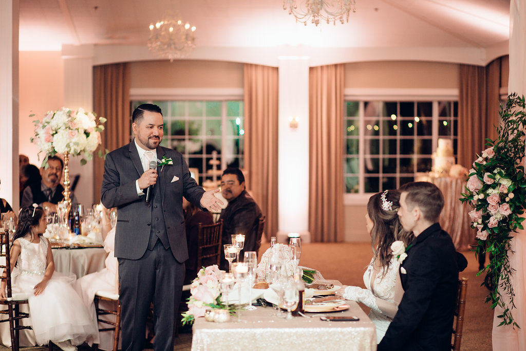 Wedding Photograph Of Man In Gray Suit Speaking To Bride And Groom Through a Microphone Los Angeles