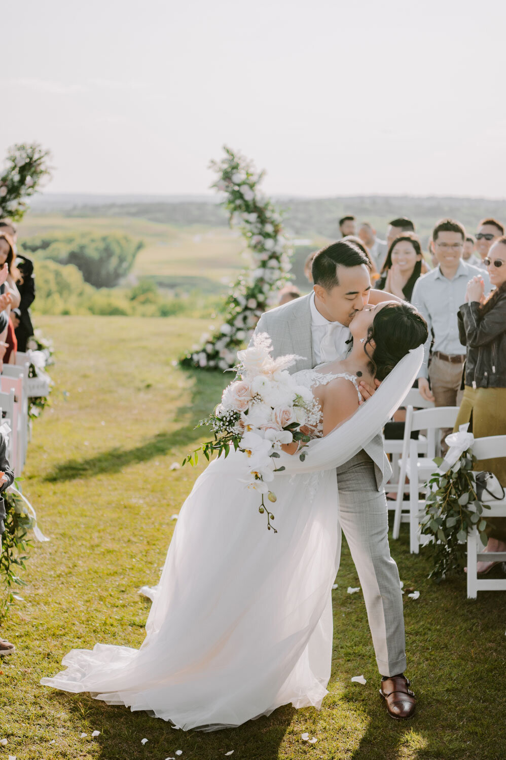 Bride and groom kissing on their wedding ceremony exit