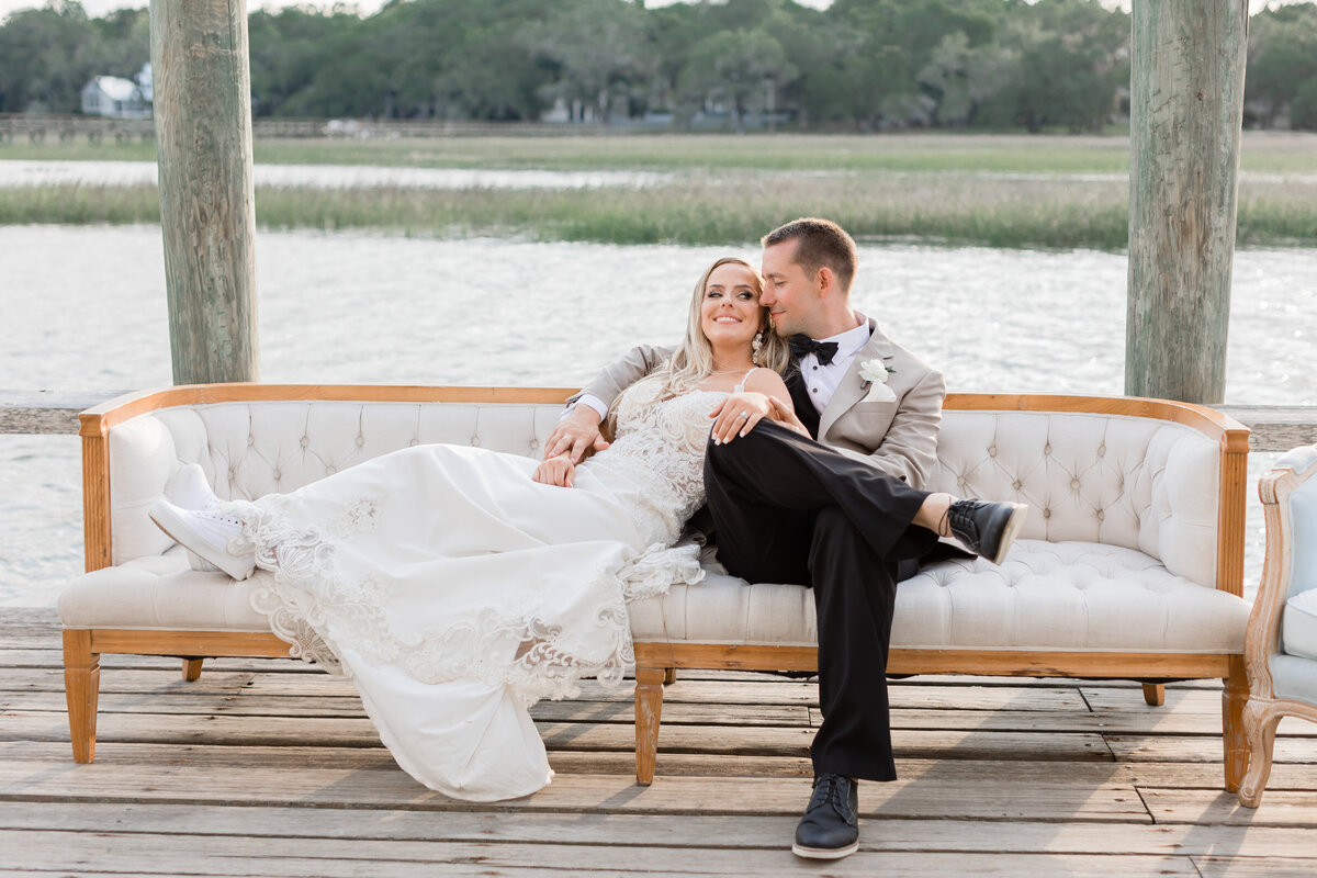 Bride and groom posing on lounge furniture at their wedding at Boone Hall in Charleston.