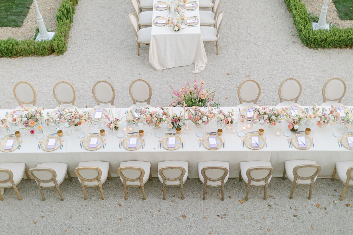Luxury wedding reception table in Provence decorated with pastel floral arrangements and candles.