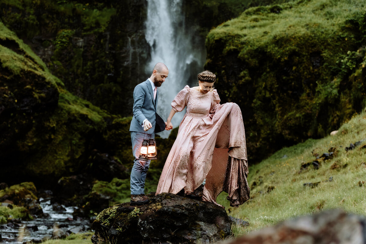 Charming photo of a couple kissing on a quaint wooden bridge in Iceland, surrounded by vibrant autumn foliage, perfect for fall wedding photography