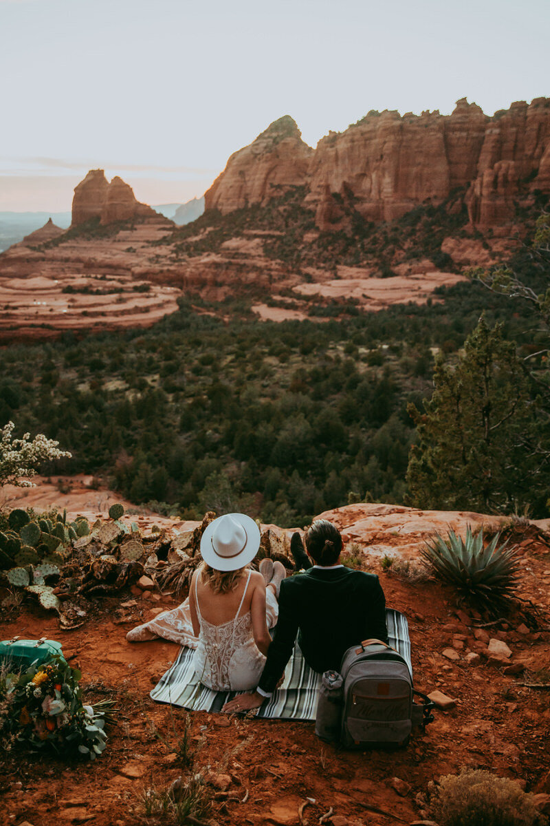 Couple sitting with red rock views and a picnic