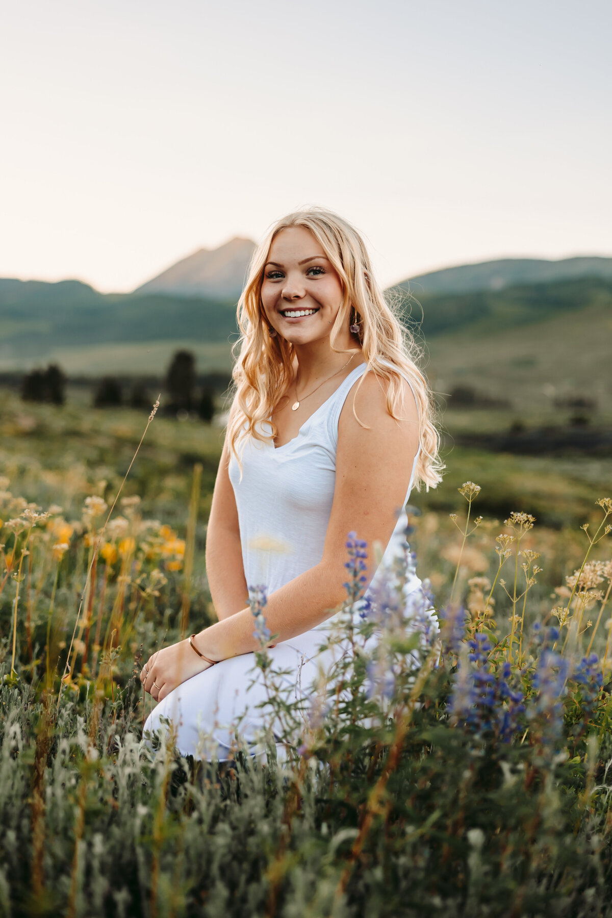 Sieanna poses near flowers for her Crested Butte senior pictures.