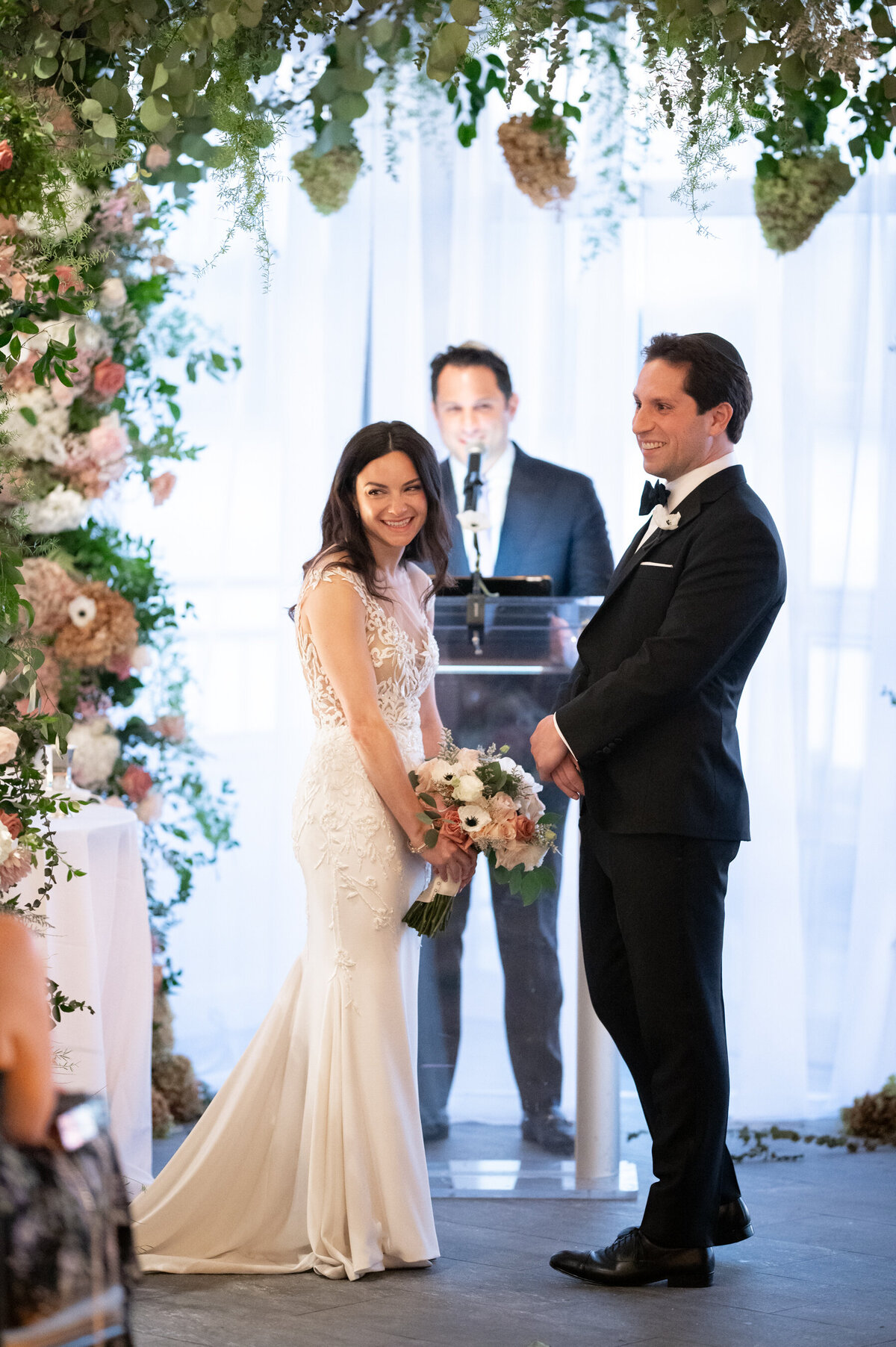 Sarah looks to the crowd and giggles during the wedding ceremony at Sunset Terrace
