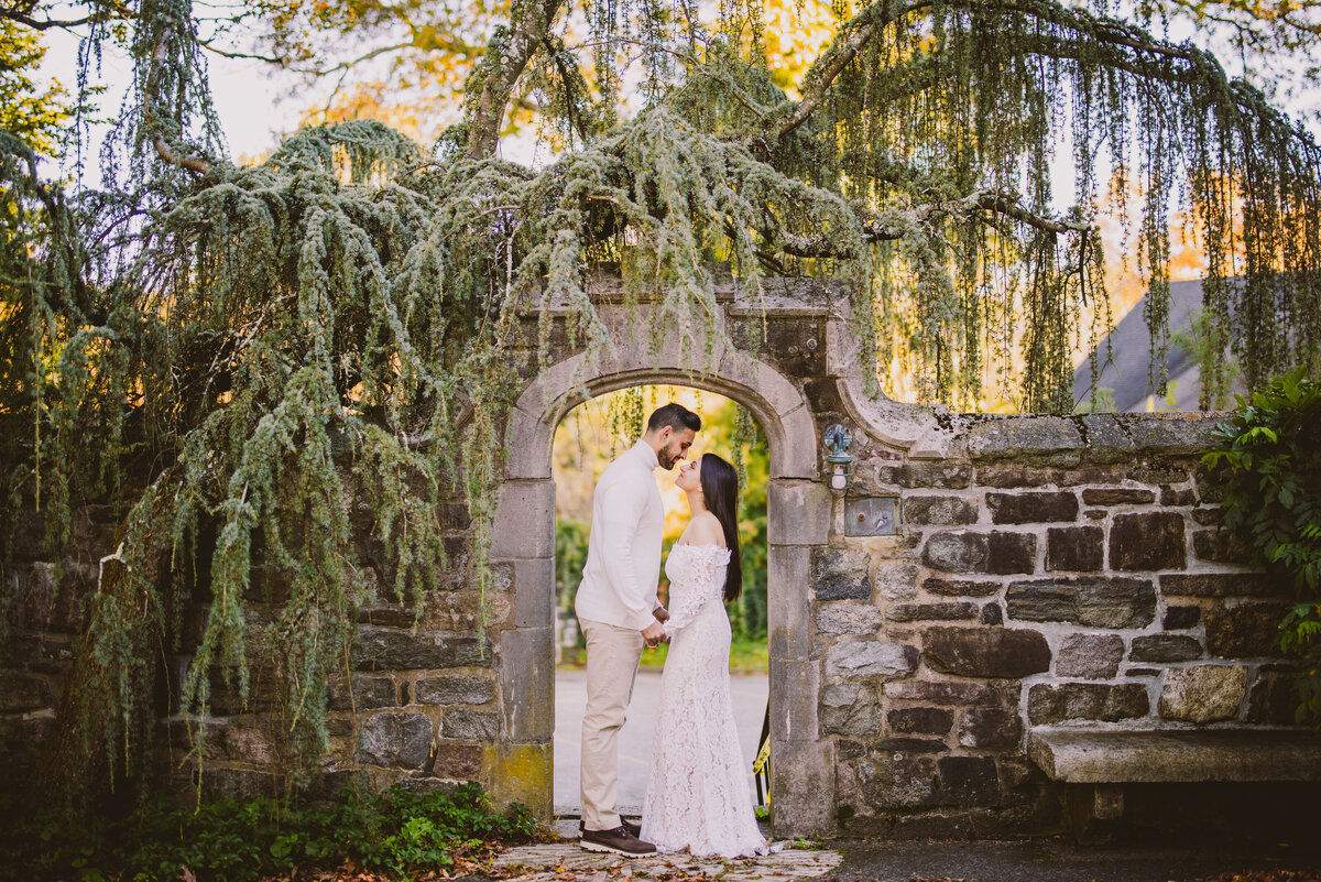 An engaged couple looking at each other under an arch at the skylands manor in nj 