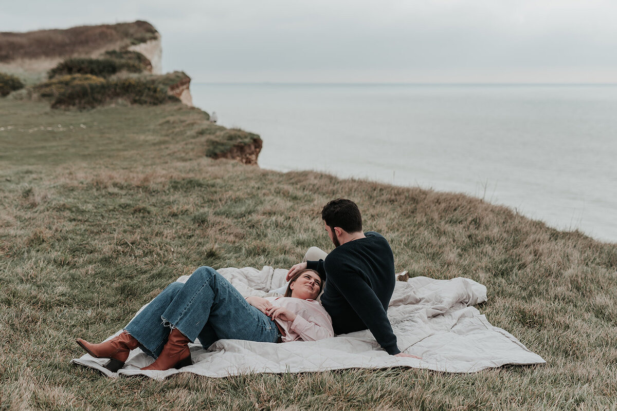 Couple relax on blanket on the cliffside at Beachy Head Eastbourne