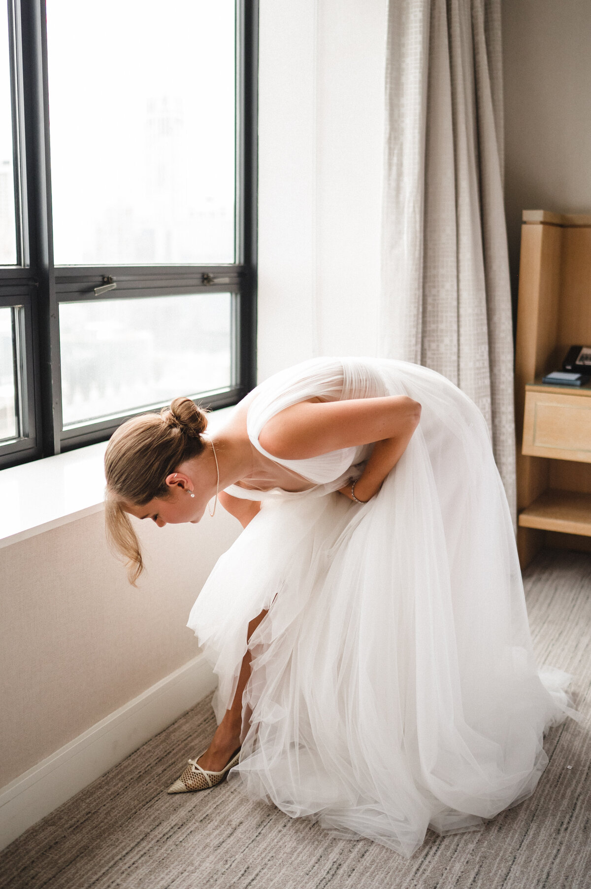 Bride putting on shoes at Ritz Carlton Chicago