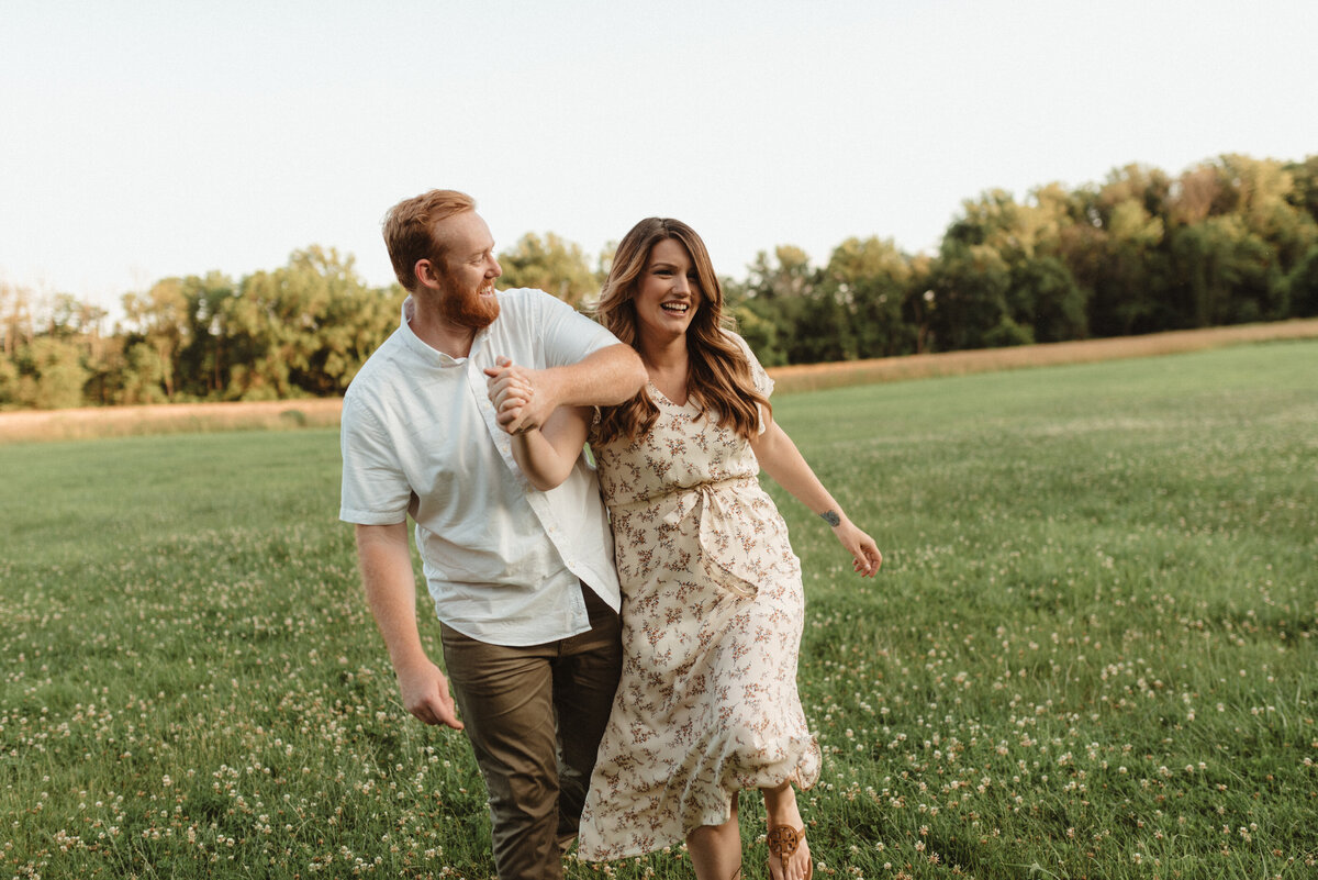 Couple laughing together in a field during a joyful photo session in Doylestown, Pennsylvania