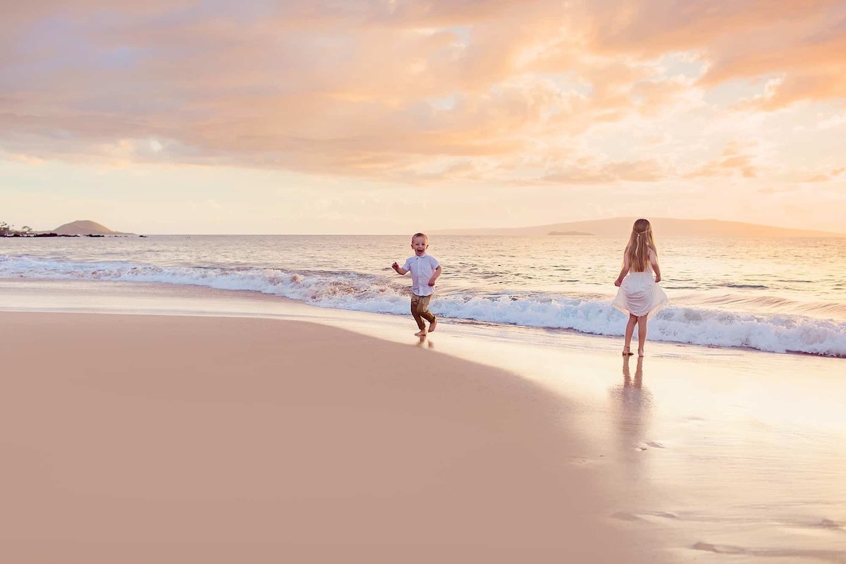 Candid family session in Wailea with kids running around the shoreline at sunset