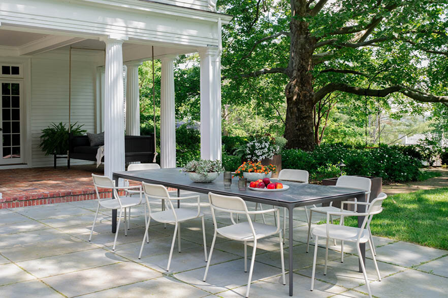 A new view of the modern patio with stacked bluestone pavers, a Gloster dining set, corten steel planters, and historic house pillars. As seen on Boston Home Magazine's Instagram.