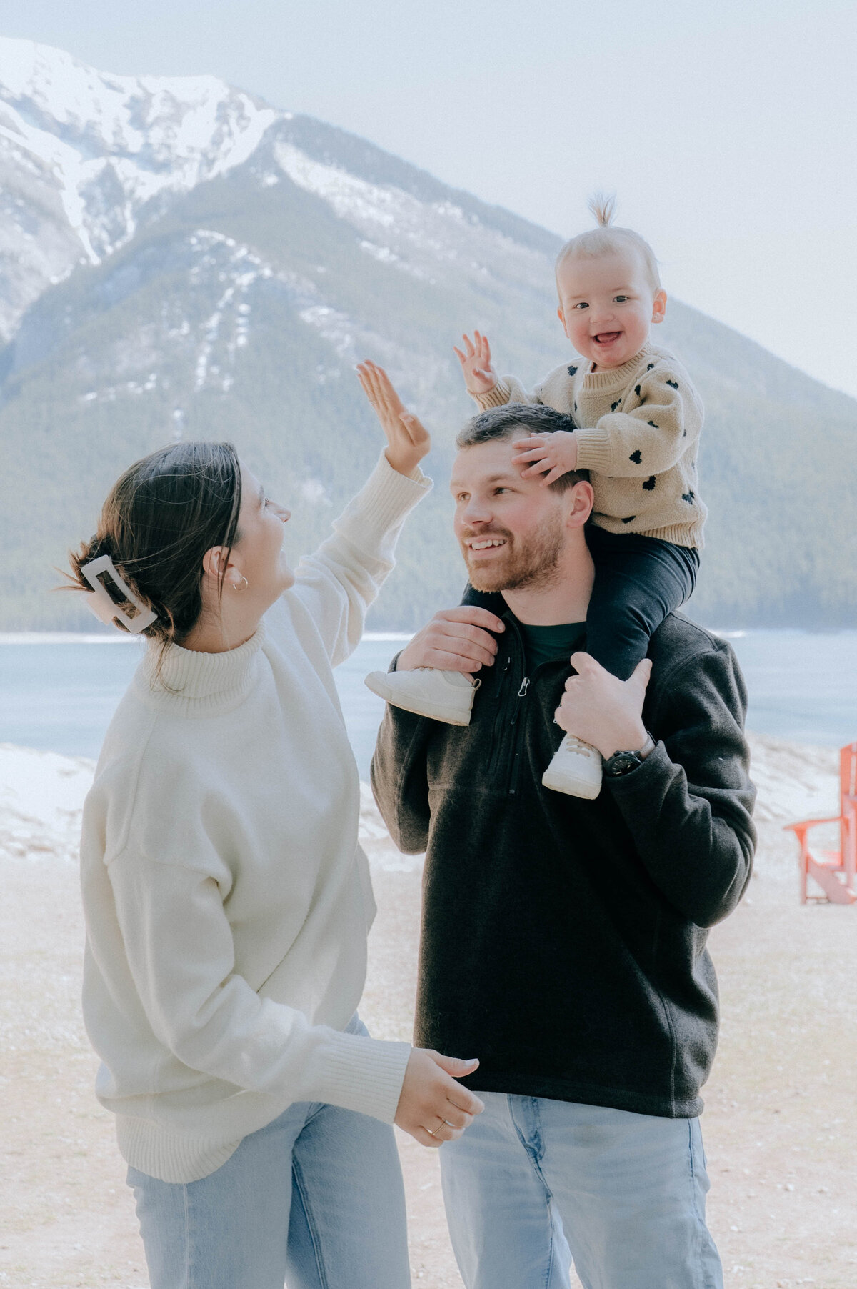 Dad carries toddler on his shoulders during joyful family shoot.