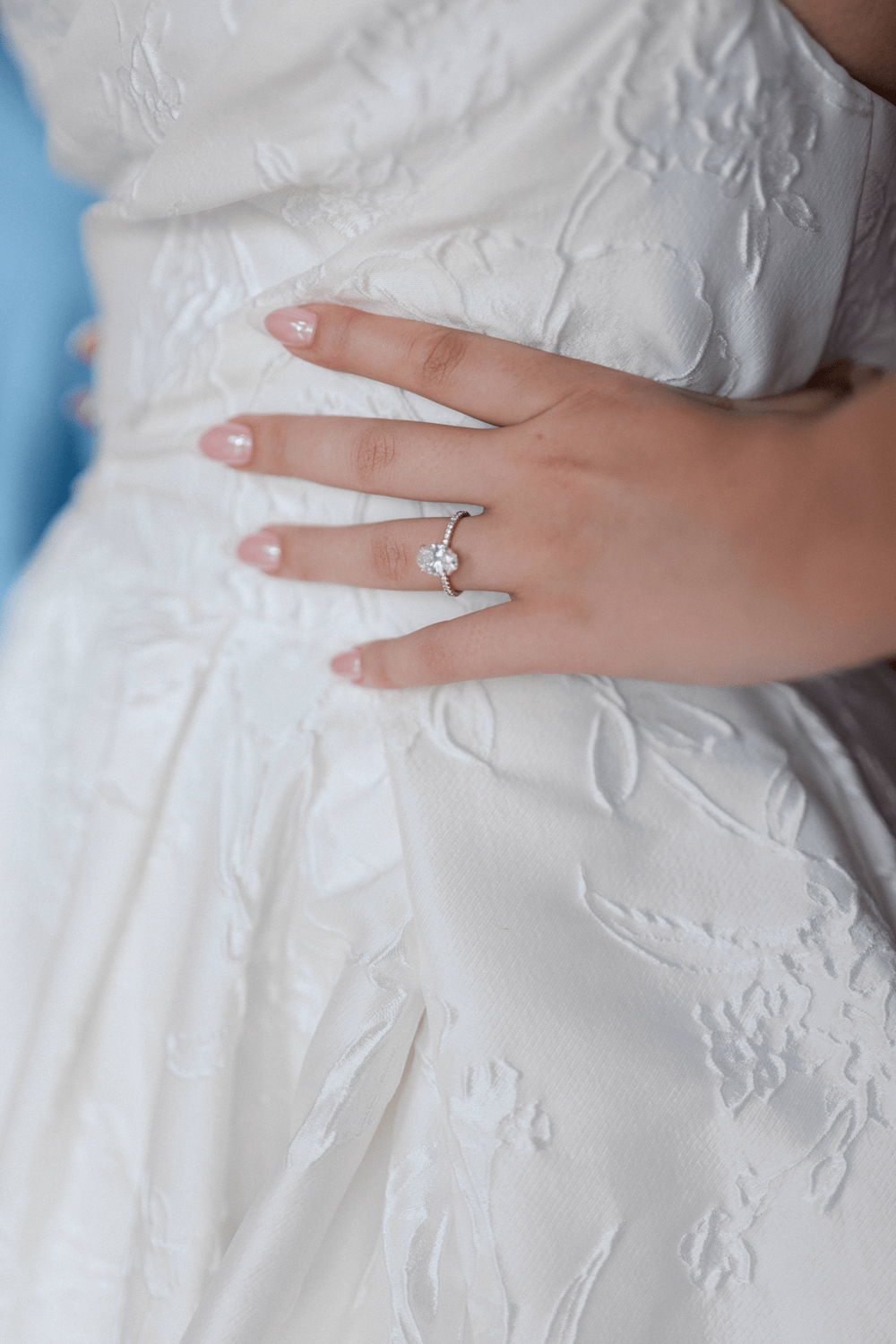 Close-up of the bride’s engagement ring and floral textured gown at a pastel wedding at Moonlight Basin, showcasing elegant bridal details.