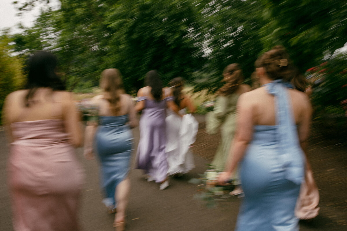 Artistic motion blur of bridesmaids walking together, capturing movement and energy in a creative Seattle wedding photography style.