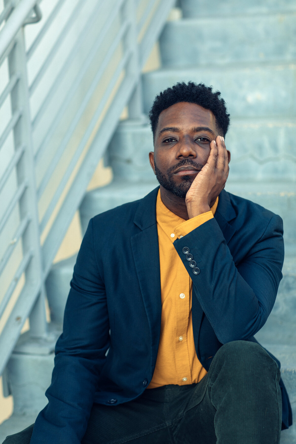 Portrait Photo Of Young Black Man Sitting On Stairs With One Hand Holding His Face Los Angeles